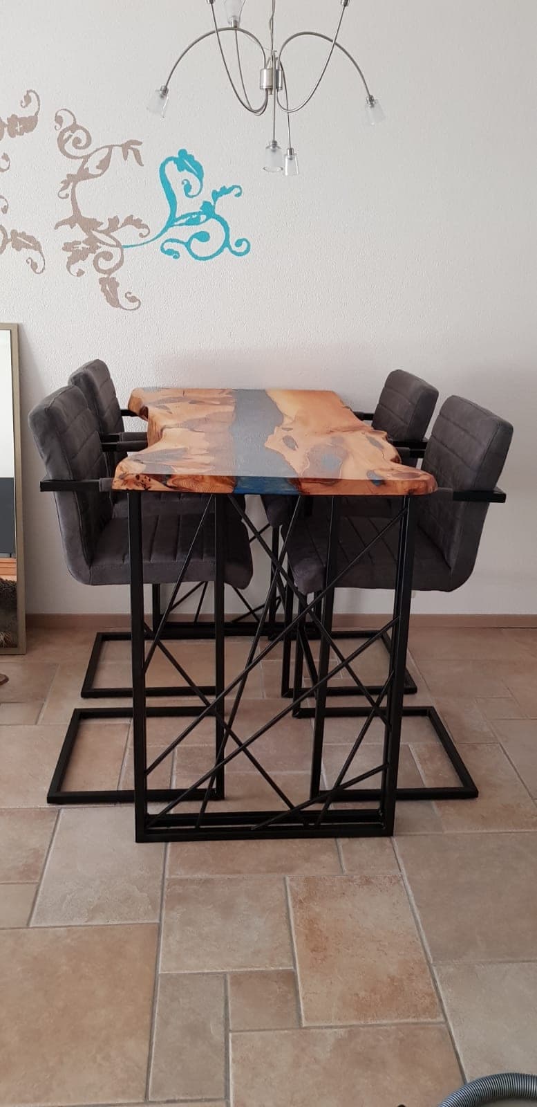 Hoge jeneverbeshouten bartafel met blauwgrijze middenstrook, zwart geometrisch onderstel en gestoffeerde barkrukken aan weerszijden.