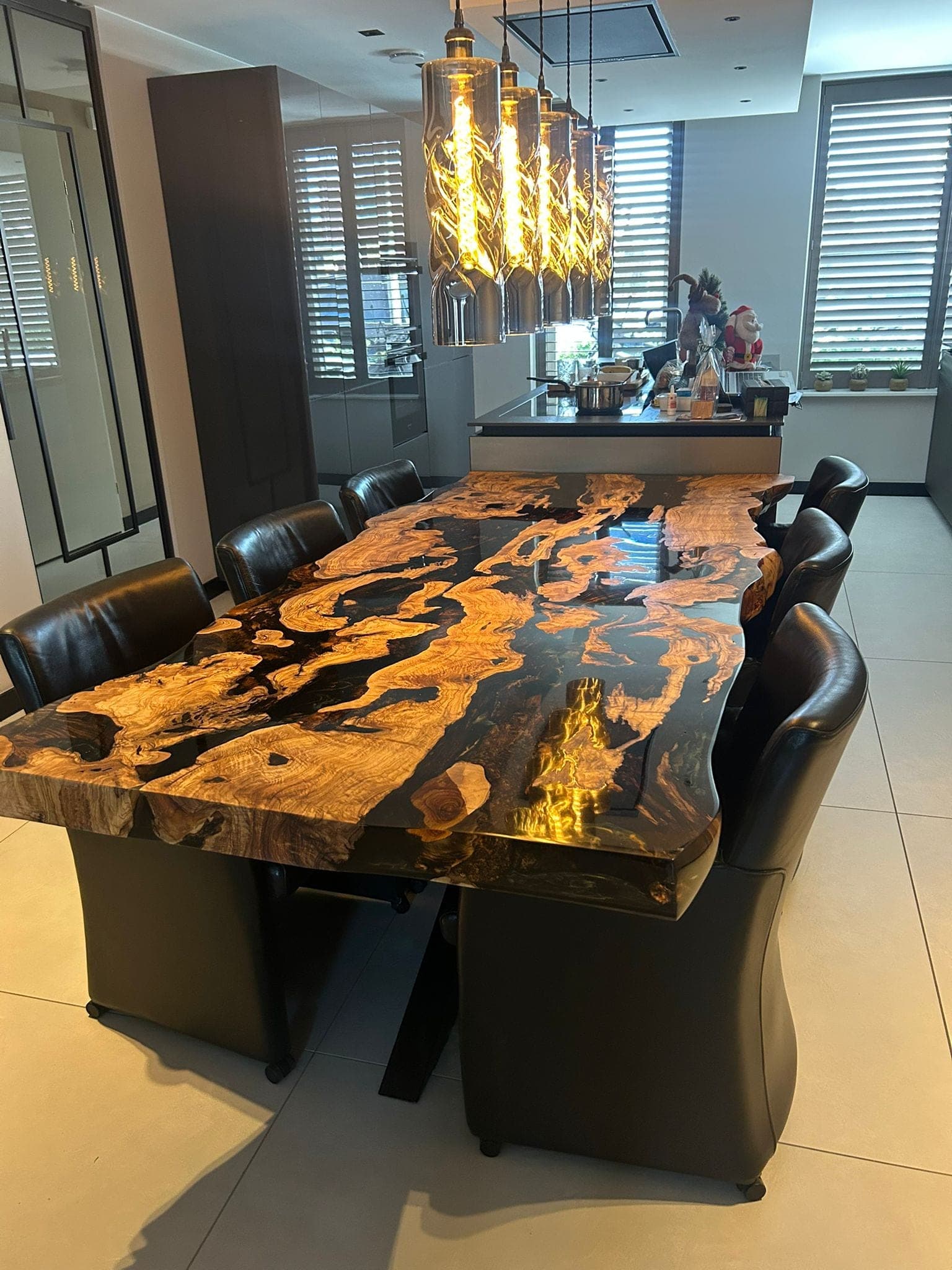 Olijfhouten eettafel met donkere epoxy en gouden houttekening