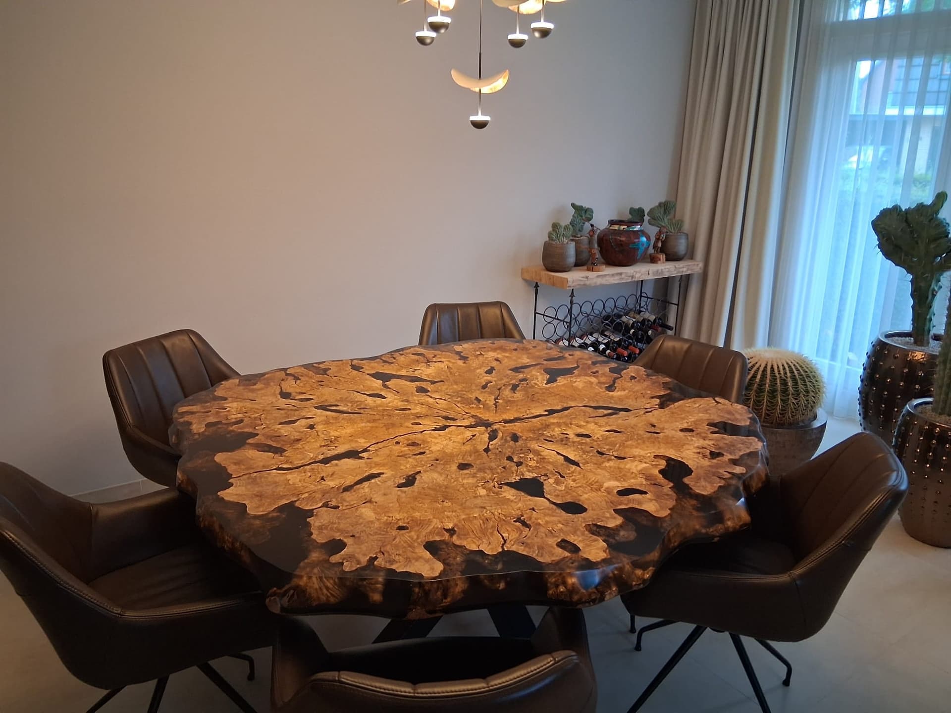 Ronde olijfhouten eettafel met donkere epoxy en natuurlijke boomkant